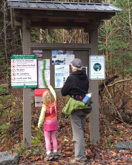 Grandparent and grandchild check out the kiosk at the southern trailhead.