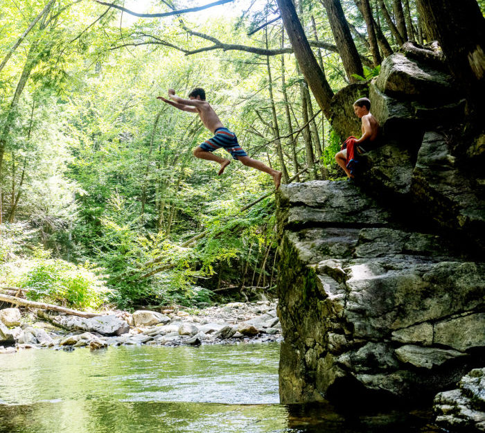 Kids jump into a Vermont swimming hole.
