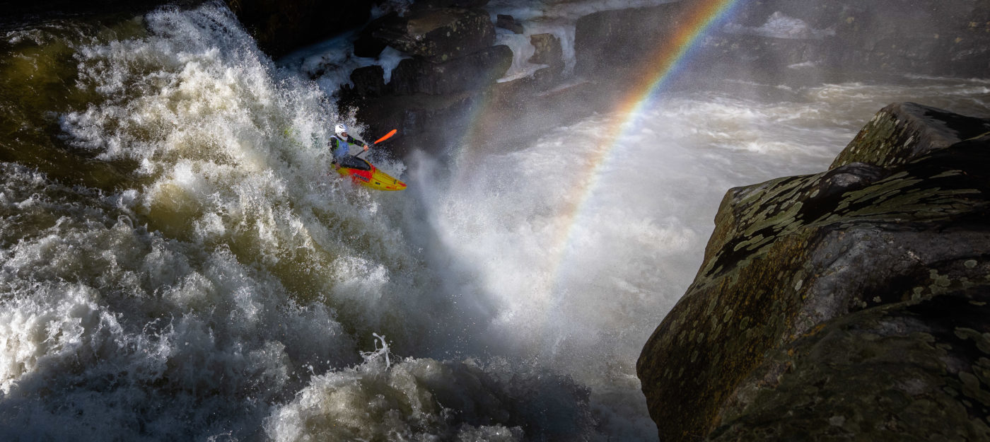 Kayaker with rainbow over waterfall © Kurt-Budliger