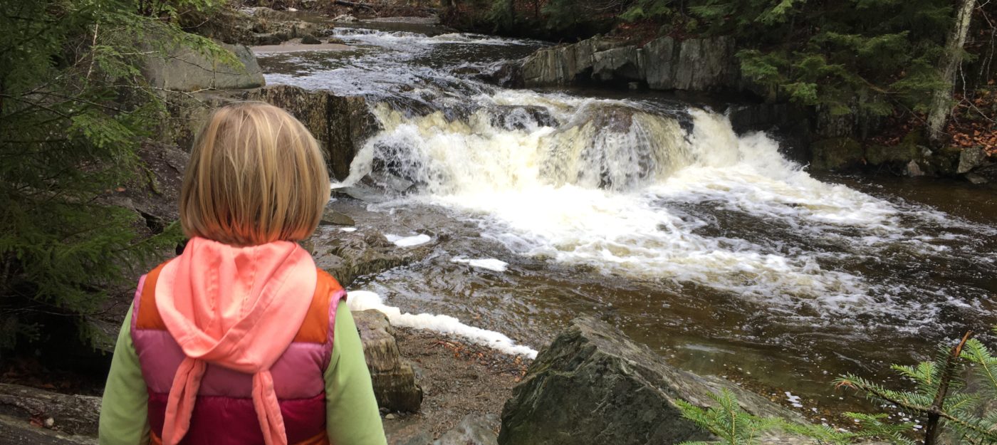 A child looks out over one of a dozen waterfalls at North Branch Cascades hiking trail in Worcester and Elmore, Vermont.