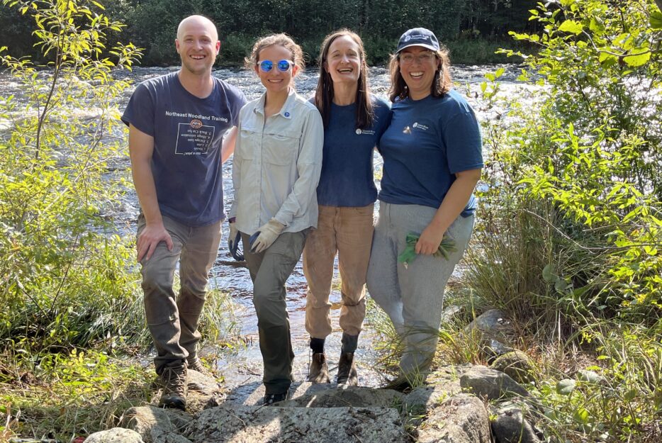 Volunteers smile as they stand near improved river access. 