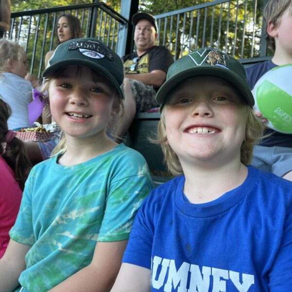 Kids smile at a baseball game