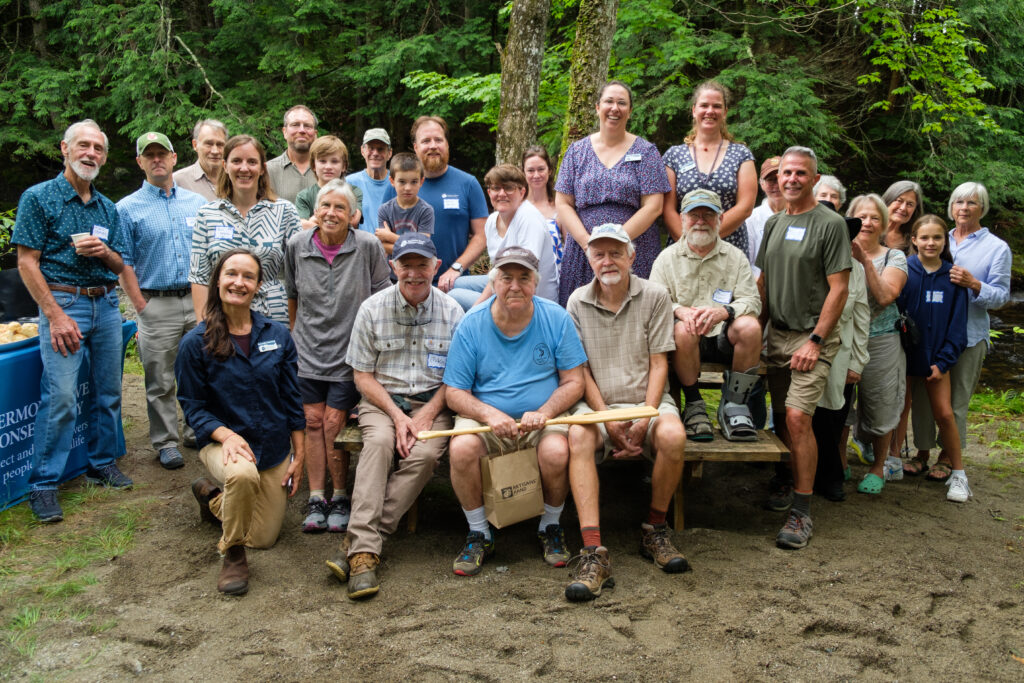 Several people stand smiling with Stephan Syz in the center.