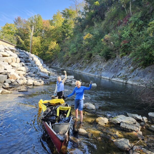 Volunteers smile after cleaning up trash and old tires from the river at last years cleanup site.